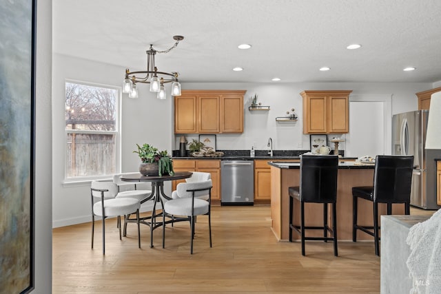 kitchen featuring an inviting chandelier, recessed lighting, a center island, dark countertops, and stainless steel appliances
