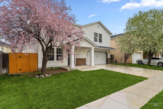 view of front facade with stucco siding, driveway, an attached garage, a front lawn, and fence
