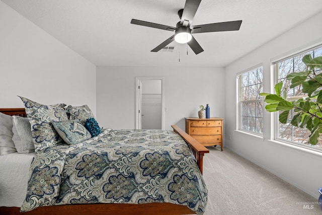 carpeted bedroom with baseboards, a ceiling fan, and visible vents