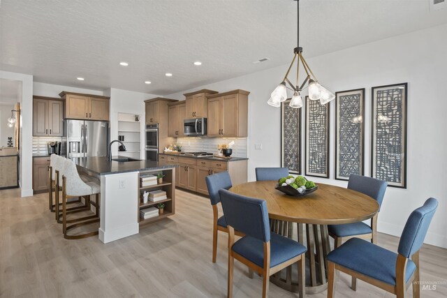 5761 N Patimos Ave, Meridian, ID 83646 - living room featuring light wood finished floors, a stone fireplace, a textured ceiling, baseboards, and recessed lighting