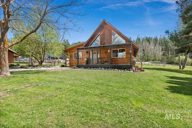 log-style house featuring a front lawn, fence, and covered porch