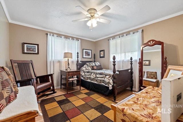 bedroom with baseboards, ceiling fan, ornamental molding, and wood finished floors