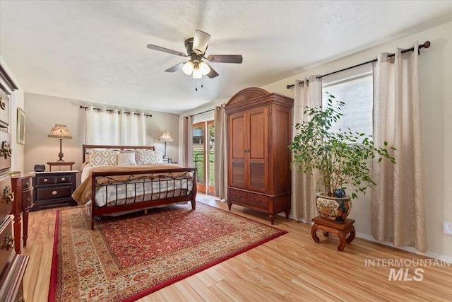 bedroom with access to outside, light wood finished floors, and ceiling fan