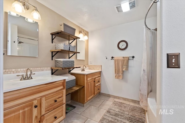 bathroom with visible vents, a sink, two vanities, and tile patterned flooring