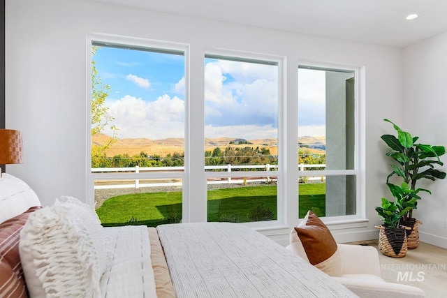 bedroom with a mountain view, recessed lighting, wood finished floors, and baseboards