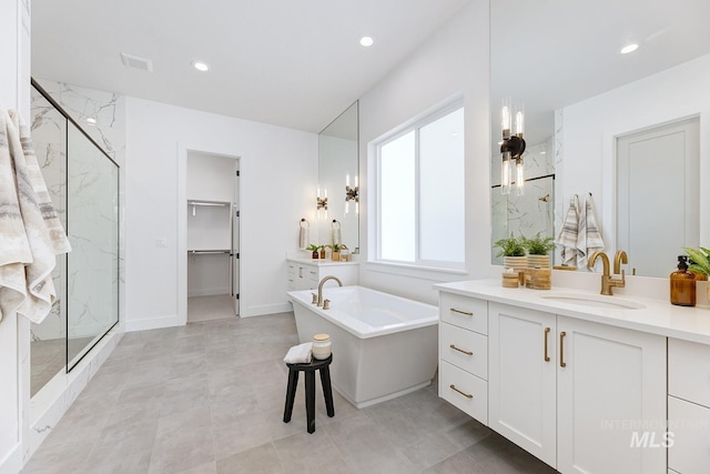 full bathroom with vanity, recessed lighting, a freestanding bath, and a marble finish shower