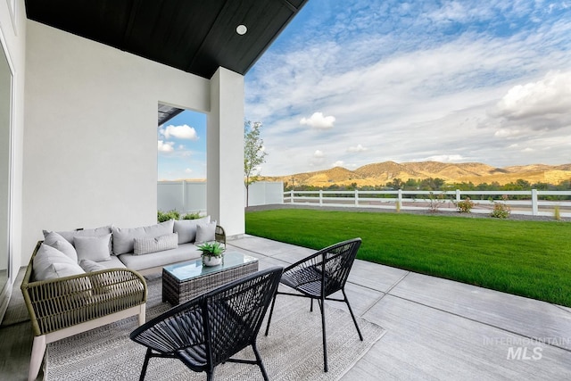 view of patio / terrace featuring a mountain view, an outdoor hangout area, and a fenced backyard