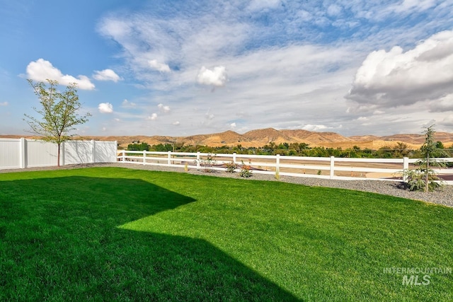 view of yard with a mountain view and fence