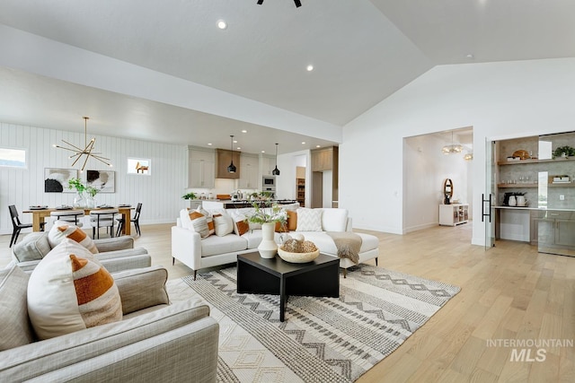living area with recessed lighting, high vaulted ceiling, light wood-style flooring, bar, and baseboards