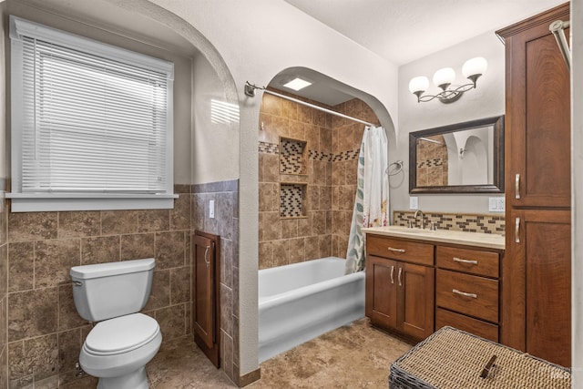 bathroom featuring tile walls, toilet, shower / tub combo, vanity, and tile patterned floors