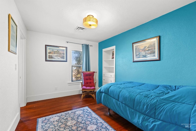 bedroom featuring baseboards, visible vents, and wood finished floors