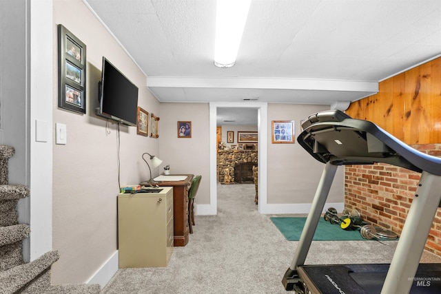 exercise room with a textured ceiling, carpet floors, visible vents, and baseboards