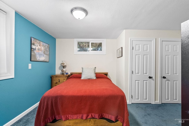 carpeted bedroom with multiple closets, baseboards, and a textured ceiling