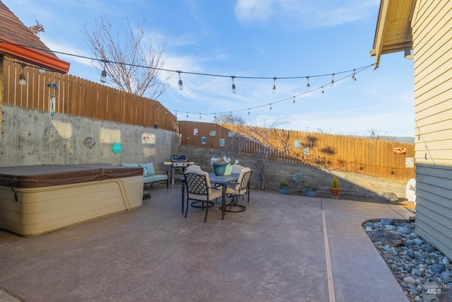 view of patio / terrace with a hot tub, outdoor dining area, and a fenced backyard