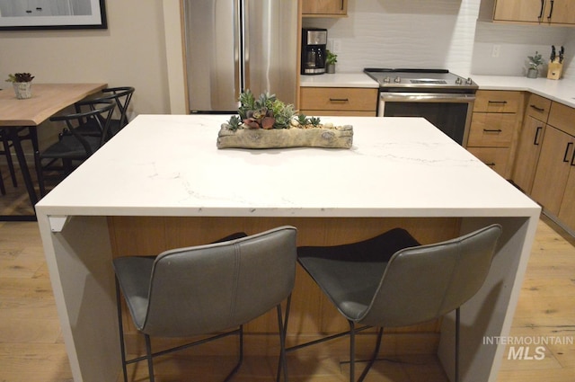 780 Village Dr Unit 308, Donnelly, ID 83615 - kitchen featuring light wood-type flooring, light countertops, a kitchen breakfast bar, and stainless steel appliances