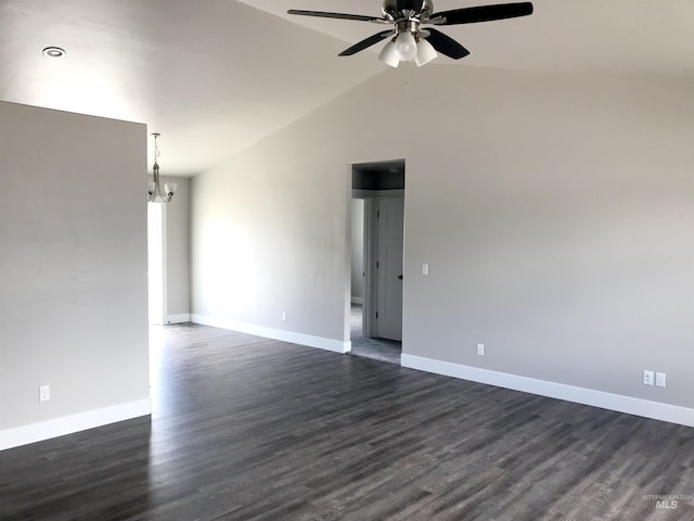 empty room featuring ceiling fan with notable chandelier, dark hardwood / wood-style floors, and lofted ceiling