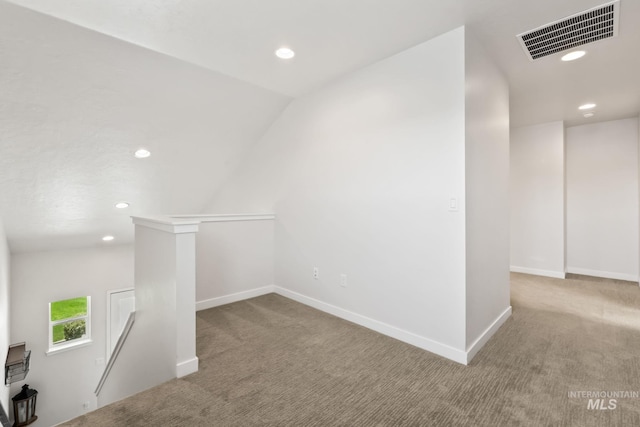 carpeted spare room with recessed lighting, baseboards, and vaulted ceiling
