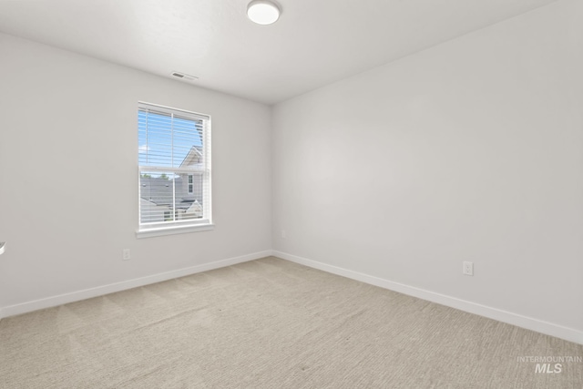 spare room featuring baseboards and carpet floors
