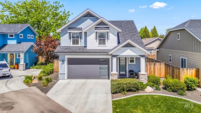 view of front facade with fence, driveway, an attached garage, and a shingled roof