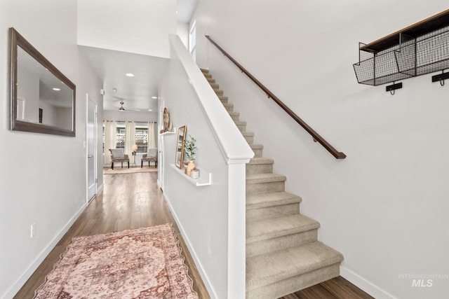 stairway with wood finished floors, ceiling fan, recessed lighting, and baseboards