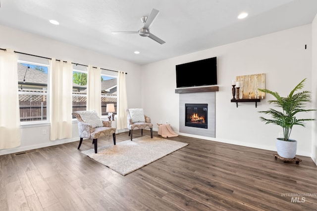 living area featuring wood finished floors, a fireplace, a ceiling fan, baseboards, and recessed lighting