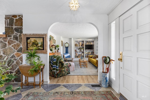 entryway featuring arched walkways and a textured ceiling