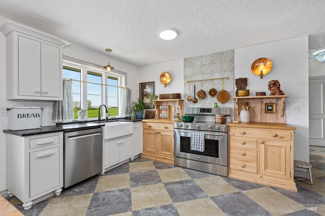 kitchen with a textured ceiling, appliances with stainless steel finishes, a sink, and open shelves
