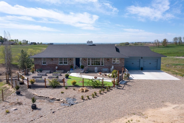 back of property featuring an attached garage, concrete driveway, a garden, and brick siding