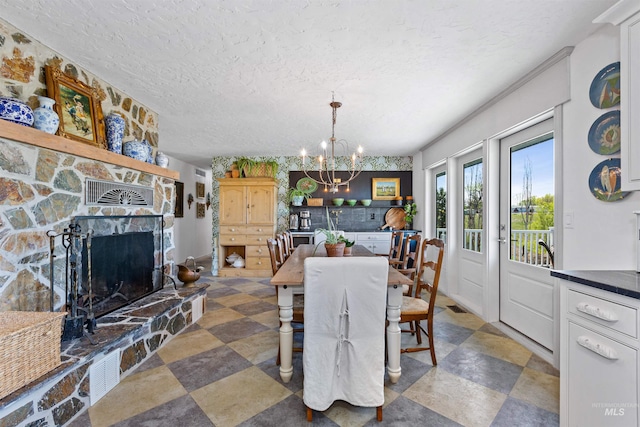 dining area with a fireplace, a textured ceiling, and a chandelier