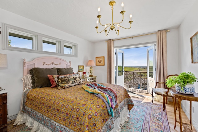 bedroom with an inviting chandelier, access to exterior, and wood finished floors