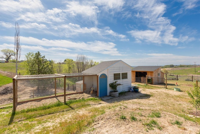 view of outdoor structure with fence and an outbuilding
