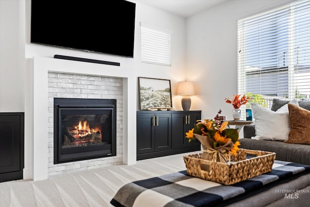 living area featuring a fireplace and carpet