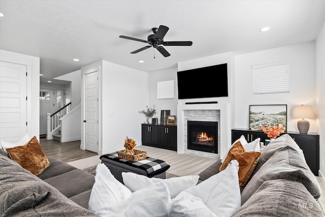 living area featuring baseboards, stairs, recessed lighting, a fireplace, and wood finished floors