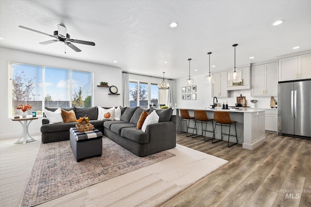 living area with recessed lighting, baseboards, wood finished floors, and ceiling fan