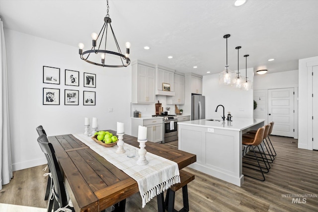 dining space with a notable chandelier, recessed lighting, baseboards, and wood finished floors