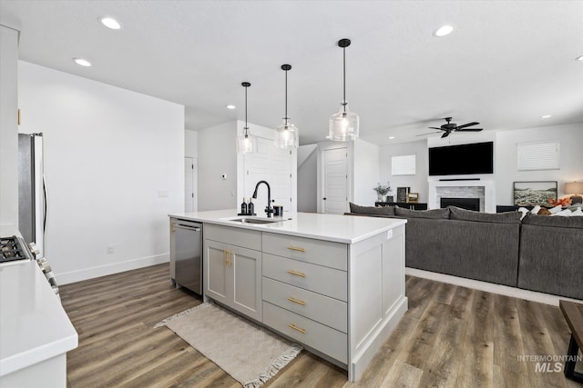 kitchen featuring a sink, refrigerator, light countertops, dishwasher, and dark wood-style flooring