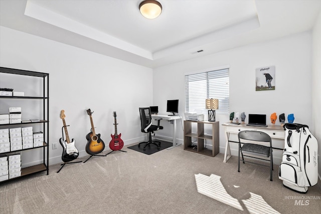 office area featuring baseboards, a tray ceiling, carpet floors, and visible vents