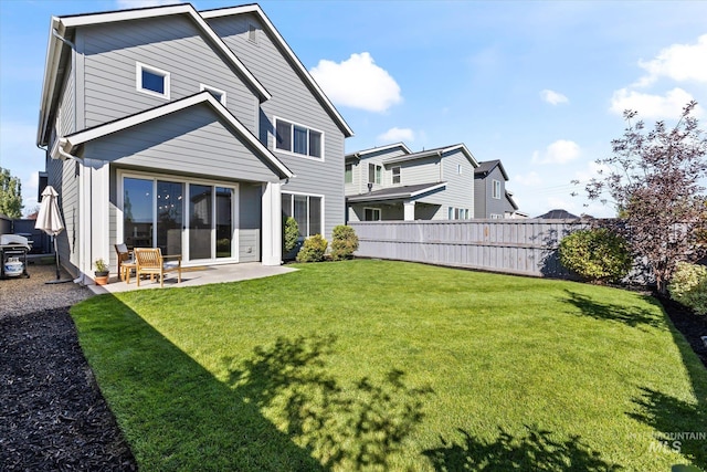 back of property featuring a patio area, a lawn, and fence