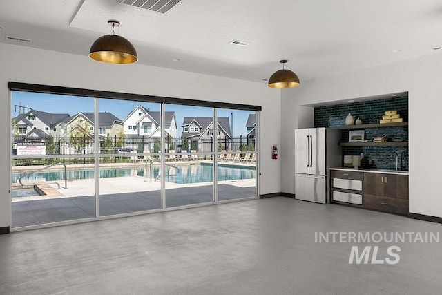 interior space with a residential view, visible vents, concrete floors, and a sink