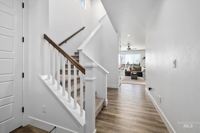 stairway featuring a ceiling fan, recessed lighting, wood finished floors, and baseboards