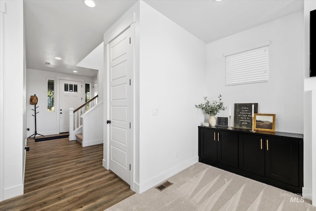 corridor featuring visible vents, wood finished floors, recessed lighting, stairway, and baseboards