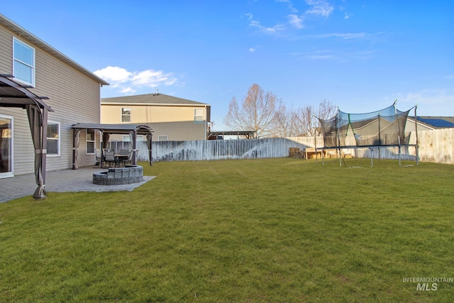 view of yard with a trampoline and a patio area