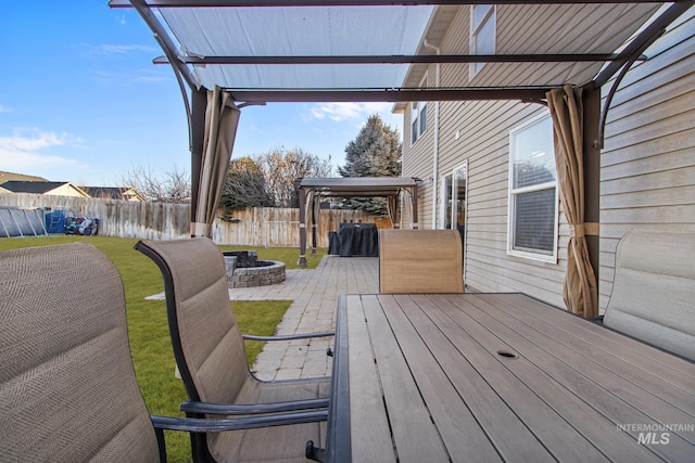 wooden deck featuring an outdoor fire pit, a gazebo, and a patio