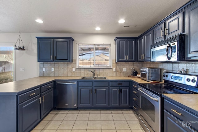 kitchen featuring tasteful backsplash, kitchen peninsula, sink, appliances with stainless steel finishes, and light tile patterned floors