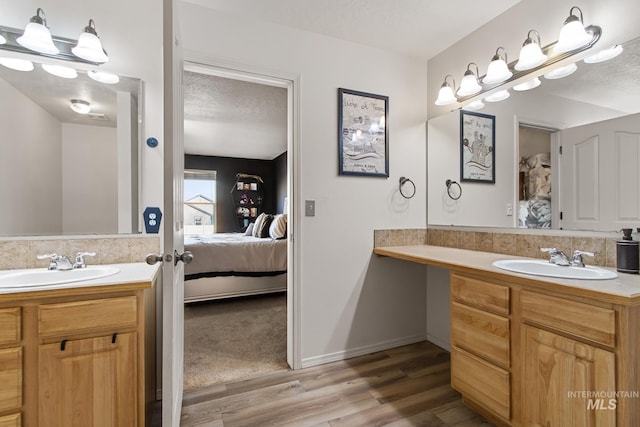 bathroom featuring wood-type flooring, a textured ceiling, and vanity