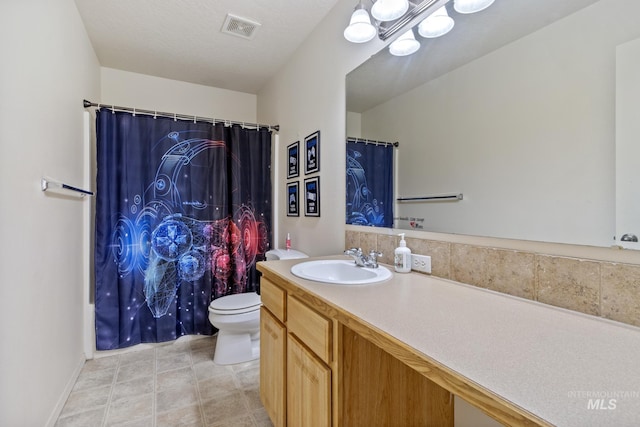 bathroom featuring toilet, a textured ceiling, and vanity