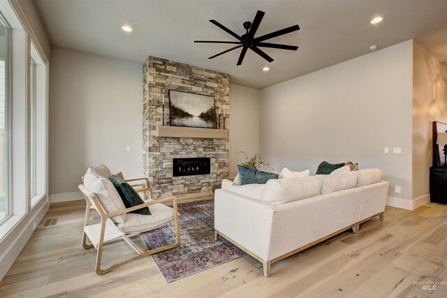 living room with ceiling fan and light hardwood / wood-style flooring