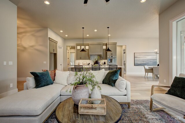 kitchen featuring backsplash, light stone countertops, hanging light fixtures, and stainless steel appliances