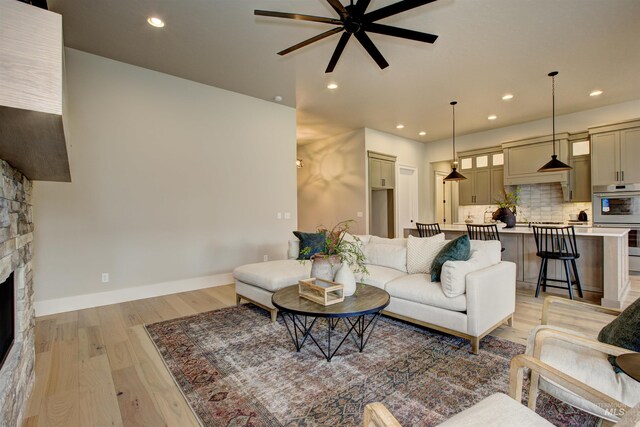 kitchen featuring pendant lighting, appliances with stainless steel finishes, sink, tasteful backsplash, and a kitchen island with sink