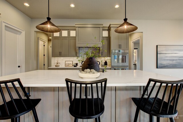 kitchen featuring light hardwood / wood-style floors, a spacious island, hanging light fixtures, and oven